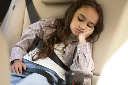 Dark-haired girl sitting in the care and looking upset and boredの写真素材
