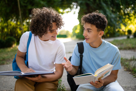 Two teens sitting in the park and studying together