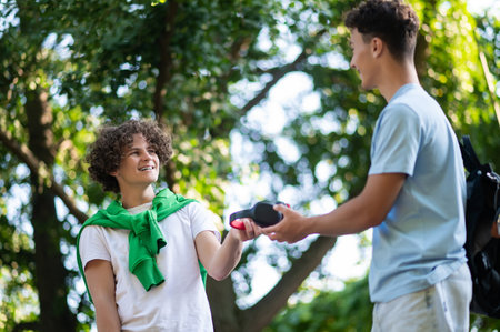 Friends meeting in the park after school and looking excitedの写真素材