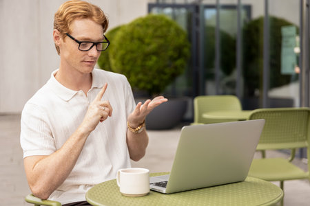 Ginger male freelancer joining video call looking at screen speaking