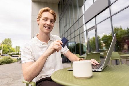 Redhead businessman making purchase using laptop filling out checkout