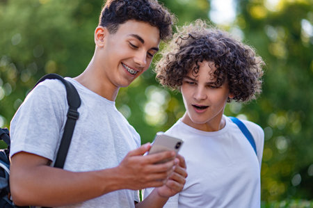 Two teens spending time together and watching something on the phoneの写真素材