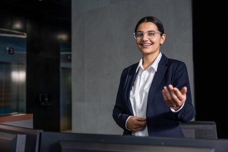 Good-looking young receptionist looking friendly and smiling nicelyの写真素材