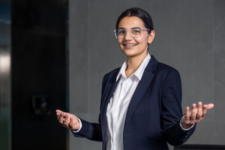Good-looking young receptionist looking friendly and smiling nicelyの写真素材