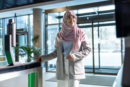 Woman in pink hijab standing in the office at the security control