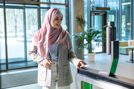 Woman in pink hijab standing in the office at the security control