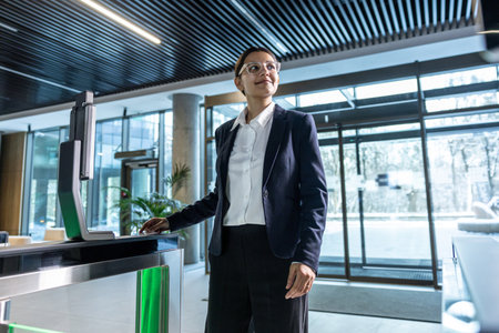 Elegant businesswoman standing near the security check point in the business center