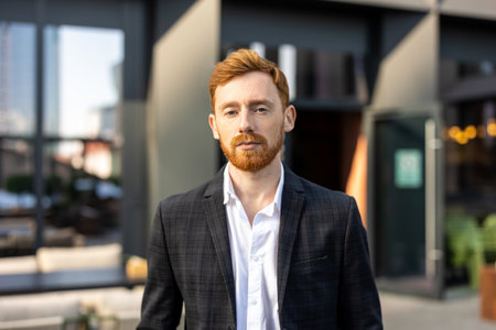 Young businessman wearing official style suit standing outdoor near office buildingの写真素材