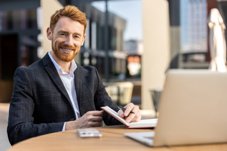 Professional in suit using paper notebook at city cafeの写真素材