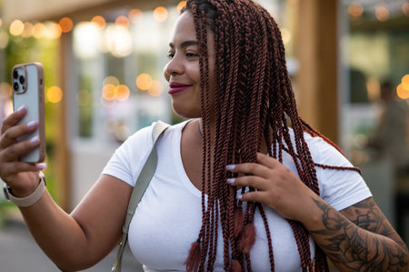 Curvy female in stylish jacket smiling while making video call