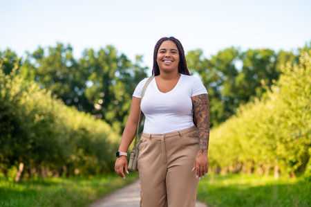 Body positive woman in casual white t shirt and beige pants strolling