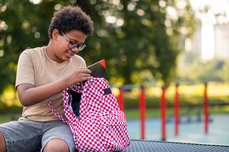 African american teen sitting at the playground after school