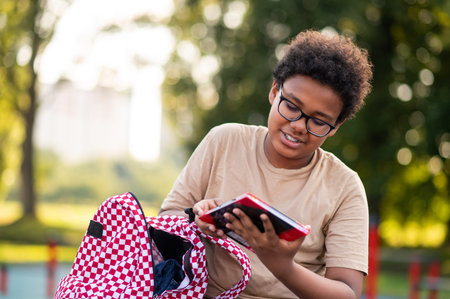 African american teen sitting at the playground after schoolの写真素材