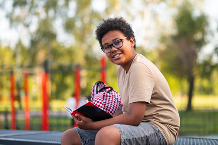 Teen sitting with a book in hand and looking contented