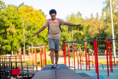 Boy at the playground walking and keeping balanceの写真素材