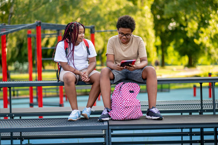 Teens sitting at the playground and talkingの写真素材