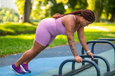 African American female in pink outfit focused on push upsの写真素材