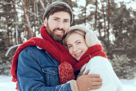 Young dark-haired man hugging his girl friend and both looking happy