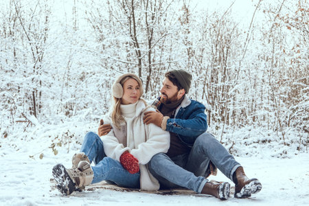 Happy young couple in the winter forest feeling excited and enjoyed