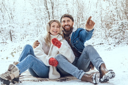 Happy young couple in the winter forest feeling excited and enjoyed