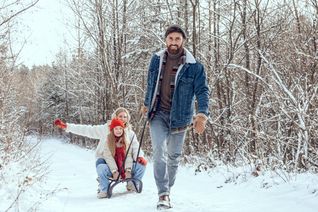 Dad pulling sled, his daughter feeling happy and enjoyed