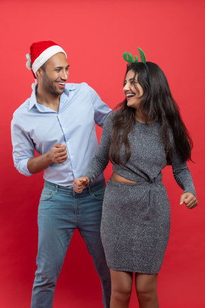 Family celebrating Christmas party dancing in festive hat and headband during New Year’s Eve