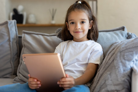 Girl using tablet for online learning in cozy home interior