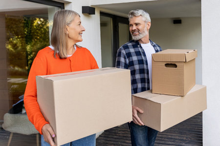 Mature couple enjoying relocation while moving boxesの写真素材
