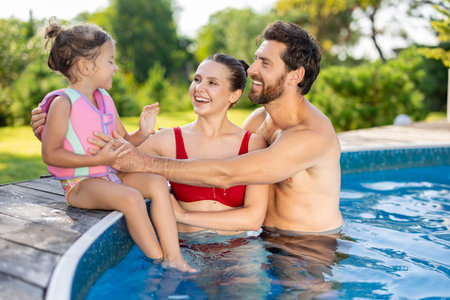 Cute family spending their day at the swimming poolの写真素材