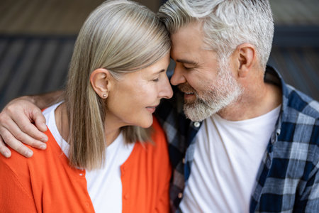Man and woman sitting together hugging and feeling in loveの写真素材