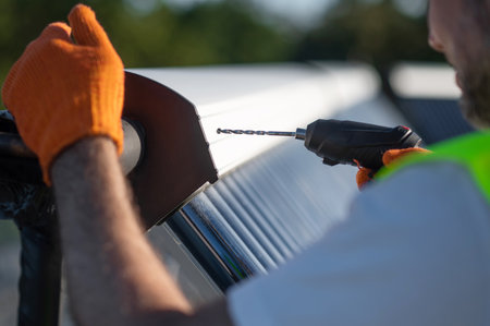 Man technician wearing gloves inspecting solar power tubes on roofの写真素材