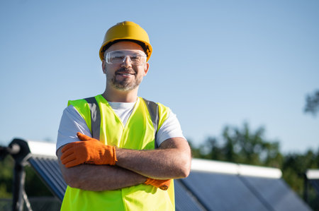 Worker standing beside solar installation smiling andの写真素材