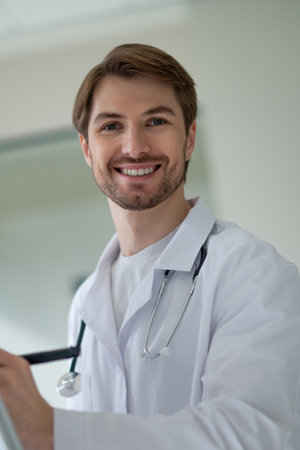 Male doctor standing next to portable white flipchart preparing for presentationの写真素材