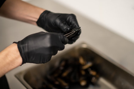 Unrecognizable chef cooking mussels in kitchen
