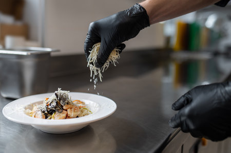 Cook garnishing seafood pasta dish with grated parmesan