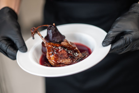Culinary expert showing plate of tender meat covered in rich sauceの写真素材