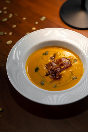 Gourmet pumpkin cream soup with elegant plating in restaurantの写真素材