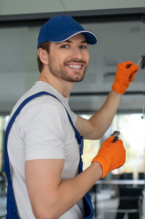 Craftsman installing hardware on glass door or partitionの写真素材