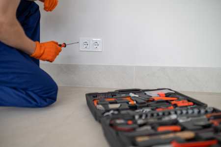 Male technician performing maintenance on power socketの写真素材