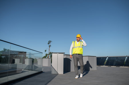 Worker in yellow vest monitoring performance of solar panelsの写真素材