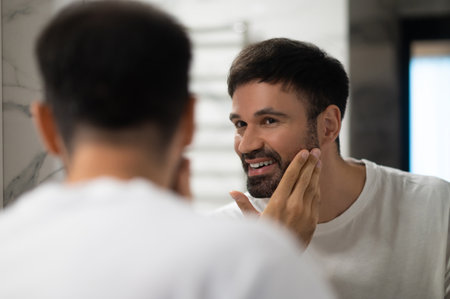 Bearded caucasian young man having his morning washing ritualの写真素材
