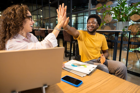 African American man in wheelchair and Caucasian woman giving high five