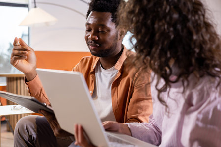 Man explaining something gesturing holding laptop during discussionの写真素材