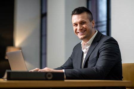 Male professional focused on laptop while sitting at desk in office