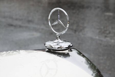 Mercedes company sign on the hood of a retro car in the rain. Moscow. 22.05.2009