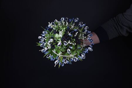 Unusual bouquet with lilies of the valley and huge shiny crystals on a black backgroundの写真素材