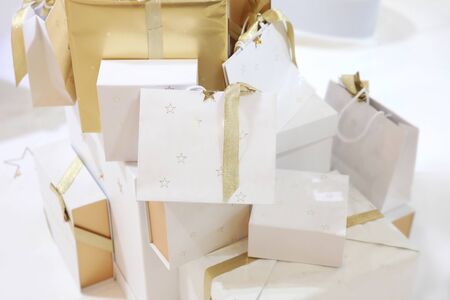 Christmas white gift bags with gold ribbons and stars, holiday gift wrapping
