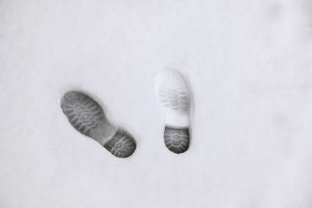 Footprints from winter shoes in the snow in the evening