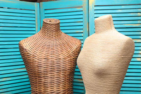 Mannequins on the background of a wooden screen painted with turquoise paintの写真素材