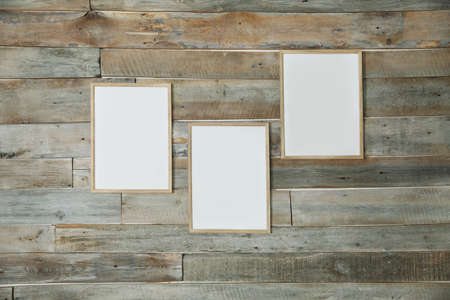 Wall of unpainted wooden boards with empty large frames for an inscription or a picturee